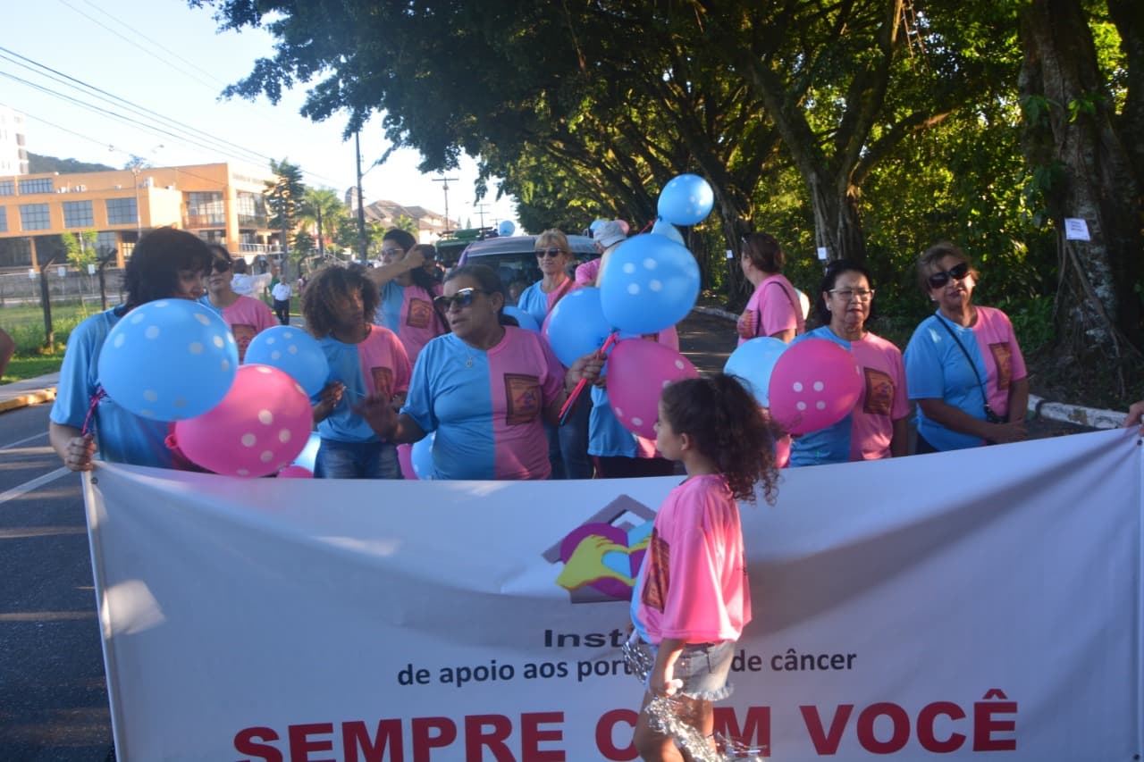 Voluntários e familiares marchando no desfile de aniversário de Joinville